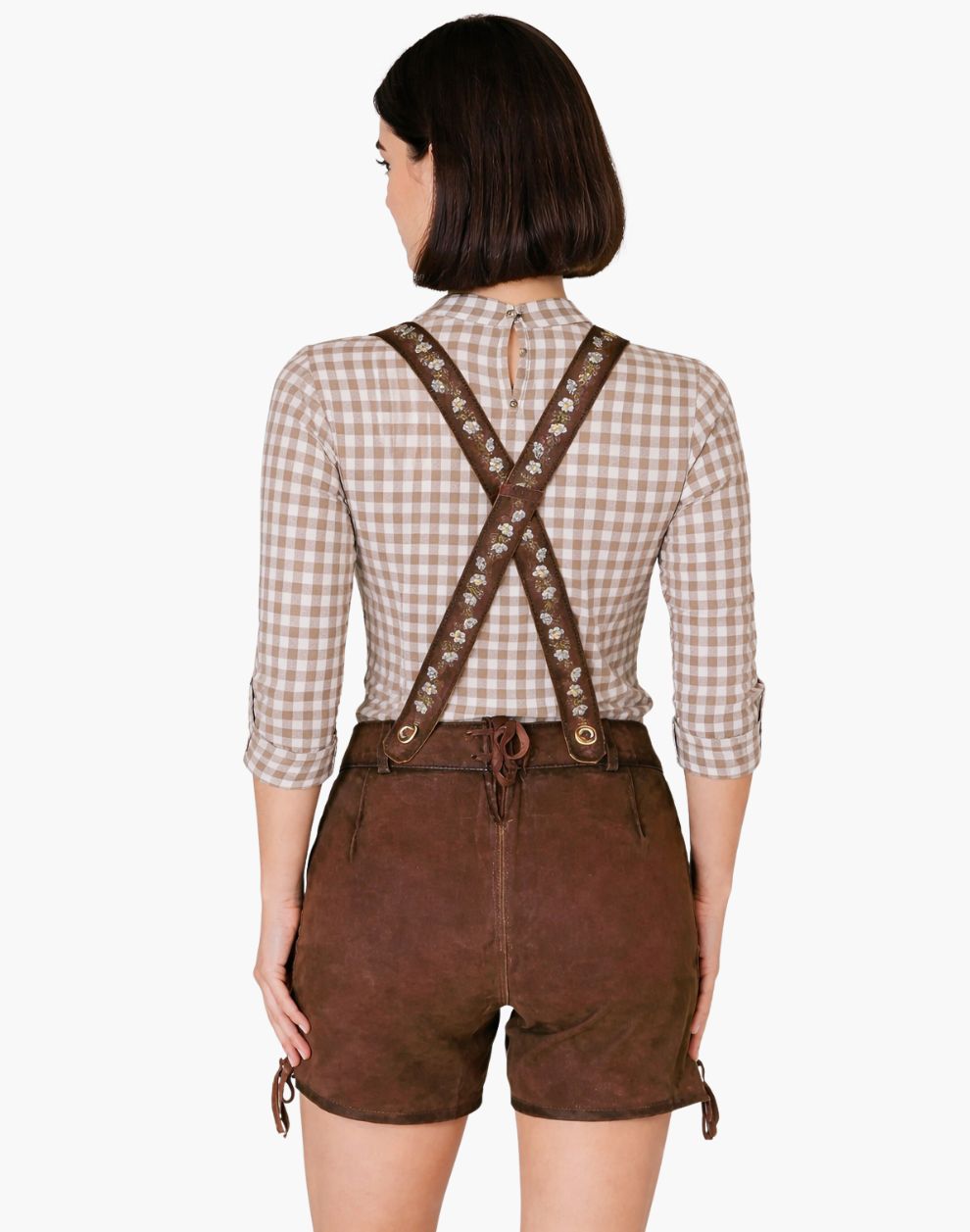 Person wearing a checkered shirt and brown leather suspenders with shorts on a white background