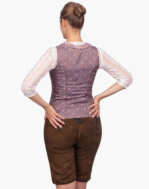 Woman wearing a patterned corset and brown shorts on a white background