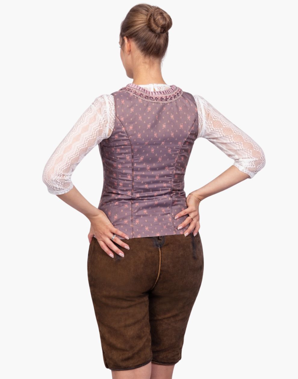 Woman wearing a patterned corset and brown shorts on a white background