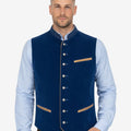 Male model wearing festival ready Trachten vest in deep blue velvet paired with Bavarian shirt and traditional Lederhosen Oktoberfest outfit