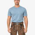 Model wearing forest scene suede lederhosen for men with Bavarian embroidery and traditional Oktoberfest style