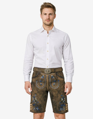 Model wearing German traditional lederhosen for men in brown leather with blue Bavarian embroidery and belt buckle