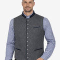 Male model wearing grey wool Trachten vest with blue piping paired with traditional Bavarian lederhosen, perfect for Oktoberfest and Alpine events.
