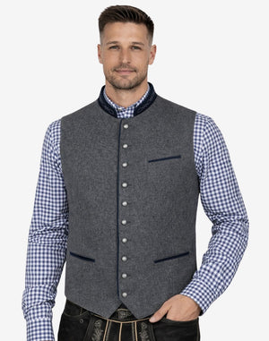 Male model wearing grey wool Trachten vest with blue piping paired with traditional Bavarian lederhosen, perfect for Oktoberfest and Alpine events.