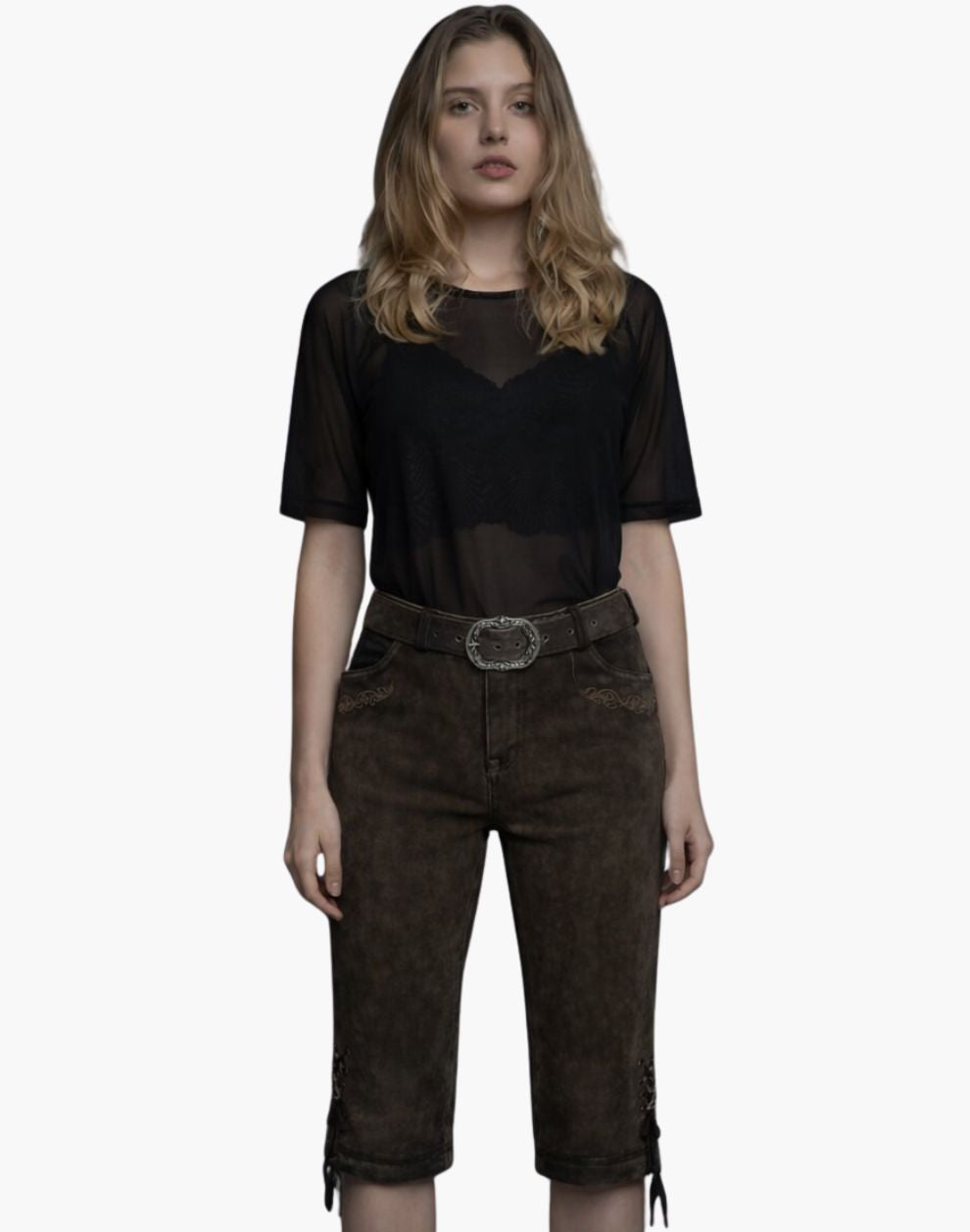 Woman wearing a black sheer top and brown shorts on a white background