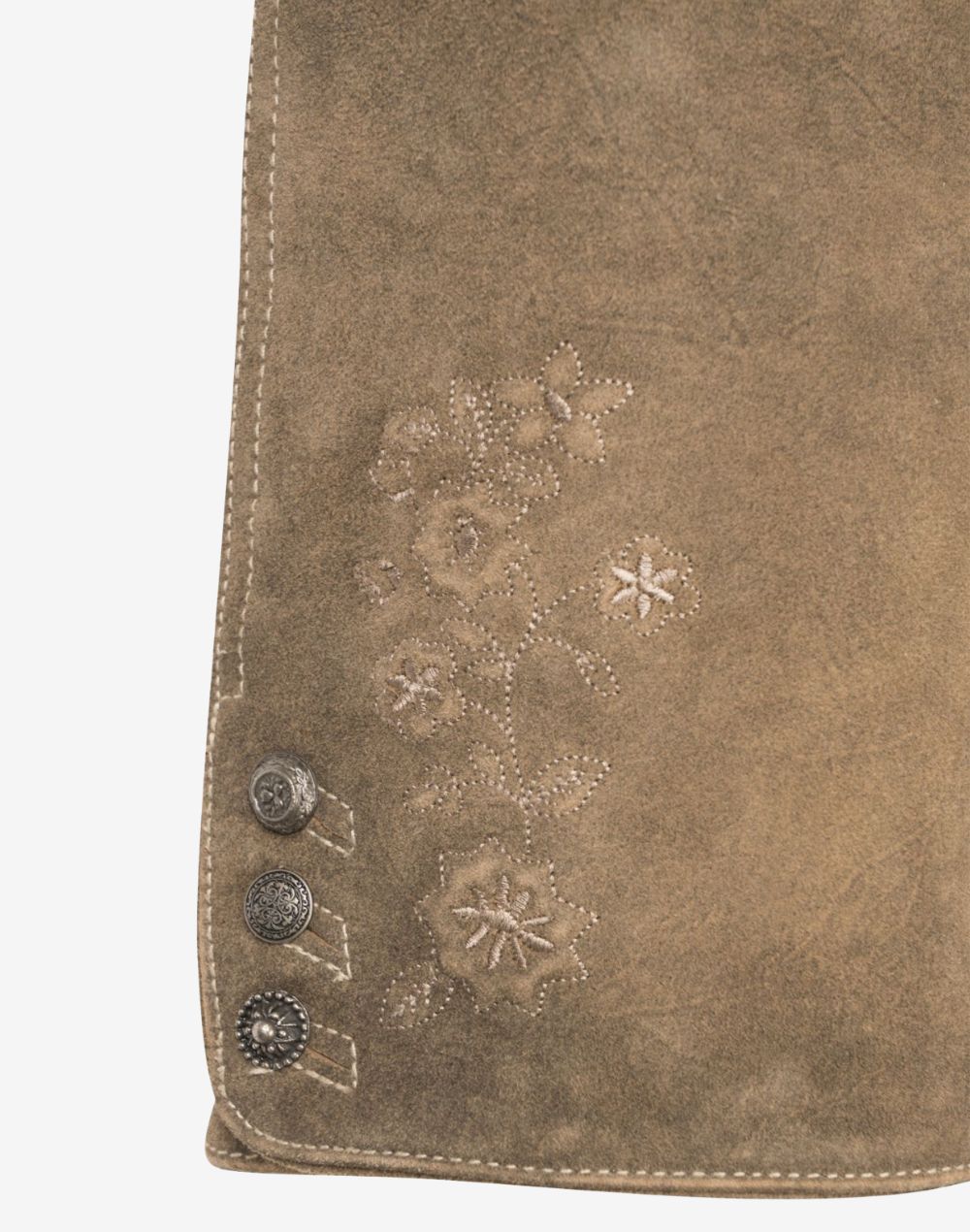 Close-up of beige suede women’s lederhosen leg featuring subtle floral embroidery and decorative metal side buttons on a soft suede leather finish.