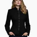 Woman wearing a luxury black Bavarian-style jacket with a high collar, decorative buttons, and a fitted tailored design, paired with dark jeans, against a white background.