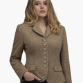 Front view of a woman wearing a camel-brown tailored jacket with a notched collar and a vertical row of decorative silver-tone buttons down the front. The fitted jacket features flap pockets at the waist and shaping seams for a defined silhouette, paired with dark trousers. The background is plain light gray.