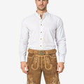 Model wearing Bavarian tan lederhosen for men in light brown leather with traditional embroidery and belt buckle