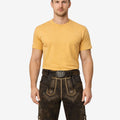 Model wearing authentic German lederhosen for men in dark brown leather with traditional Bavarian embroidery and belt