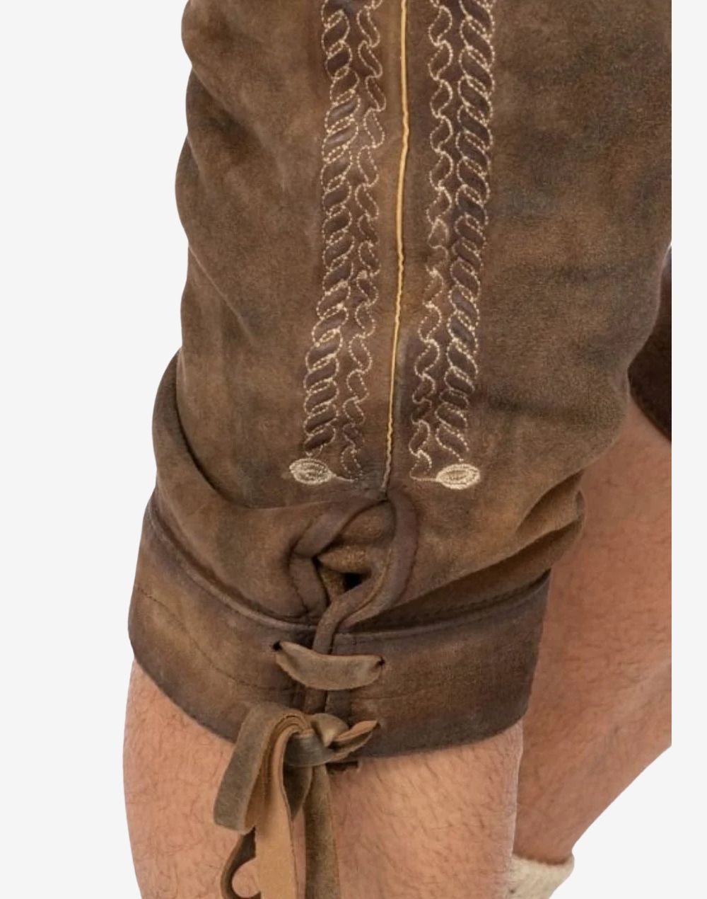 Close-up of knee section showing embroidered leg design and leather lace fastening typical of bundhosen styling