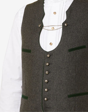 Close up of mens elegant Trachten vest showing vintage brown fabric, decorative metal buttons and classic Bavarian tailoring.