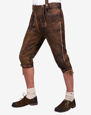 Side angle view of mens heritage style bundhosen highlighting leg embroidery, knee ties and authentic leather aging effect