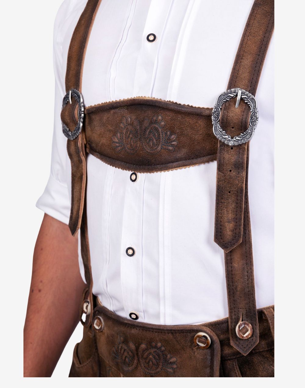 Close up of bundhosen suspenders displaying leather straps, metal buckles and embossed detailing in traditional Bavarian style