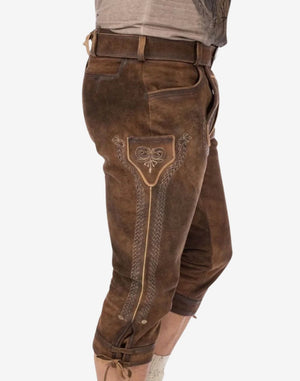 Angled wearing view of mens leather bundhosen showing side stitching, leather shading and traditional knee length fit.