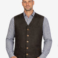 Model wearing mens rustic brown leather Trachten vest paired with checkered shirt and jeans, highlighting vintage finish, classic Bavarian style and versatile Oktoberfest outfit appeal.