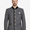 Model wearing grey Trachten jacket front view featuring stand collar, wooden buttons and classic Bavarian festival styling.
