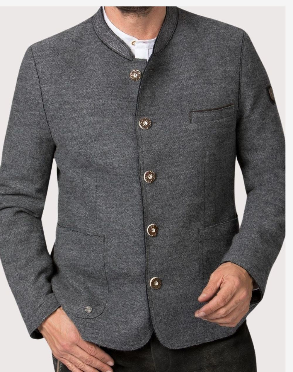Front portrait view of model wearing gray alpine jacket highlighting horn buttons, wool texture and Bavarian Oktoberfest style.