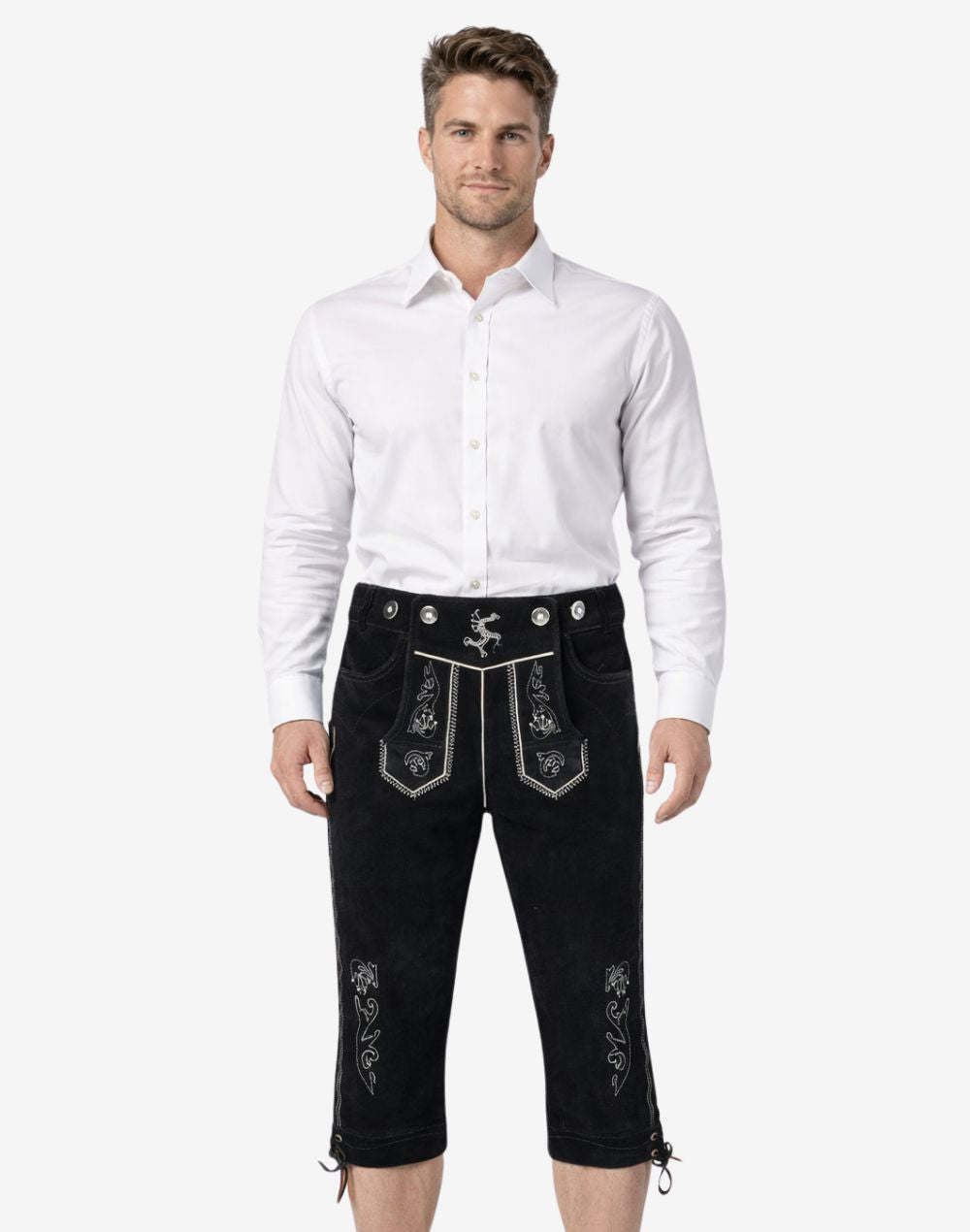 Front view of model wearing mens traditional Bavarian Bundhosen in black leather with embroidered Bavarian motifs and knee-length ties for Oktoberfest style
