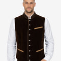 Male model wearing traditional Bavarian vest in brown velvet paired with white shirt and Lederhosen, styled for Oktoberfest festival clothing and Alpine heritage fashion.