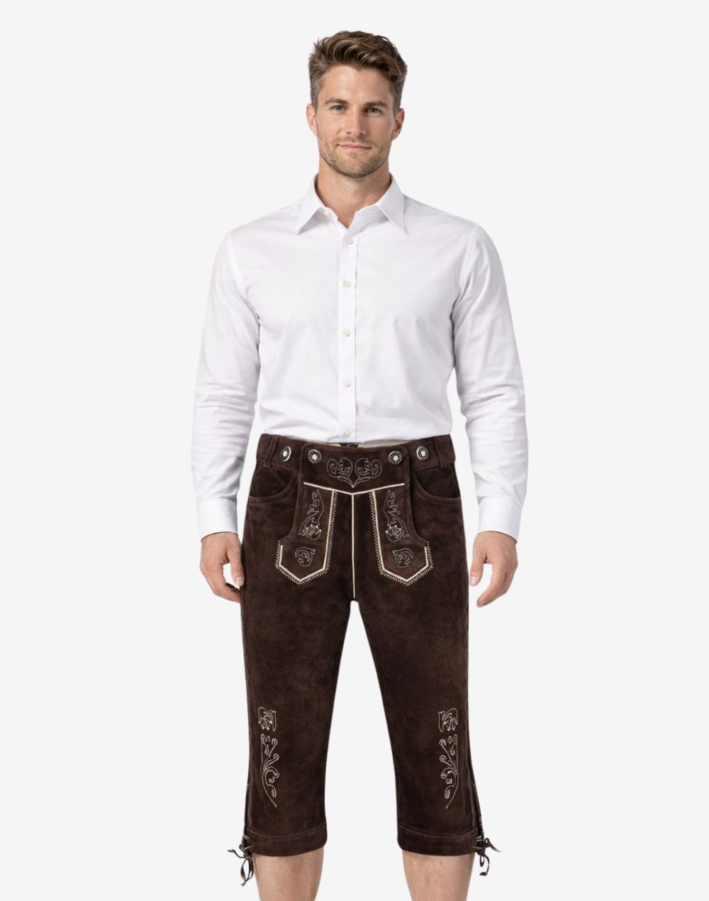 Men's dark brown leather Bundhosen worn with a white shirt featuring light embroidery, adjustable suspenders, and lace-up knee openings.