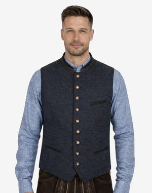 Model wearing navy blue wool Trachten vest for men paired with traditional Bavarian outfit, ideal for Oktoberfest and Alpine occasions.