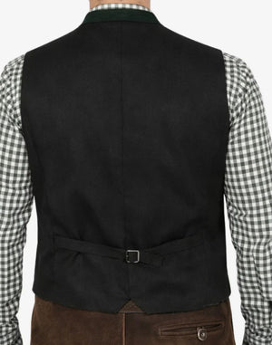 Black vest worn over a checkered shirt with brown pants on a plain background
