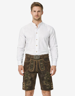 Model wearing Oktoberfest leather shorts for men in dark brown leather with Bavarian embroidery and belt buckle