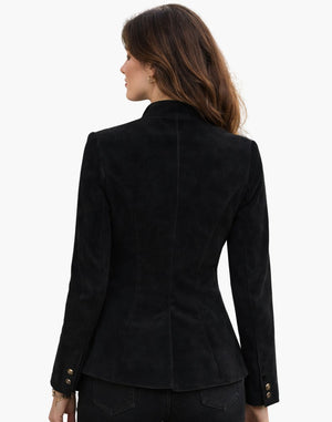 Back view of a woman wearing a black Trachten jacket with a fitted silhouette and traditional Bavarian tailoring, paired with dark bottoms, against a white background.