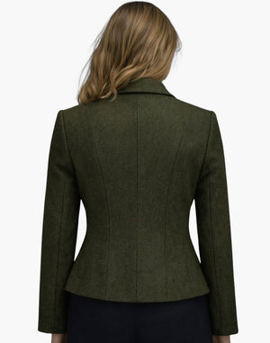 Back view of a woman wearing the same olive green fitted jacket, highlighting the shaped seam lines and slightly flared hem. The jacket is styled with dark trousers, and her shoulder-length blonde hair falls naturally over the collar. The background is plain light gray.