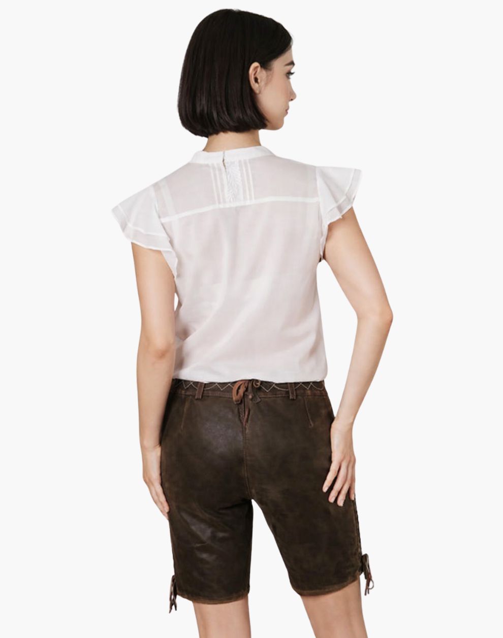 Woman wearing a white top and brown leather shorts on a white background
