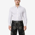 Model wearing premium alpine lederhosen for men in black leather with traditional Bavarian embroidery and belt
