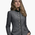 Woman wearing a gray blazer with buttons on a white background