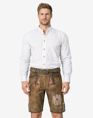 Model wearing premium Bavarian lederhosen for men in brown leather with traditional embroidery and belt buckle