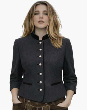 Woman wearing a premium German Trachten jacket in dark grey with a high collar, pearl-style buttons, and tailored traditional Bavarian design, paired with brown lederhosen, against a white background.
