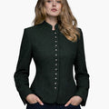 Woman wearing a dark green Trachten-style jacket with decorative buttons, high collar, and a fitted tailored design, paired with dark jeans, against a white background.