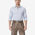 Model wearing premium mens Oktoberfest lederhosen in brown leather with Bavarian embroidery and traditional belt buckle for festival attire
