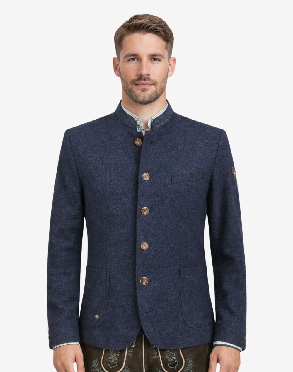 Model wearing rustic dark blue German heritage jacket for men with stand collar, traditional Trachten style, button front, and paired with lederhosen for Oktoberfest outfit.