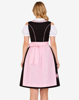 Back view of model wearing rustic German dirndl dress featuring structured bodice, pink apron bow and classic Bavarian silhouette