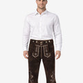 Front view of model wearing rustic leather Bundhosen for men in dark brown with Bavarian embroidery and traditional Oktoberfest knee tie details