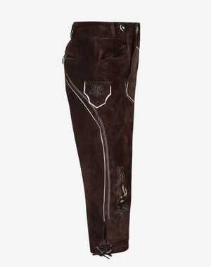 Side angle view of rustic leather bundhosen displaying contrast stitching, side pocket design and traditional knee tie closure
