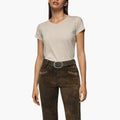 Woman wearing a beige t-shirt and brown Bundhosen with a belt on a white background