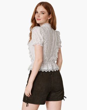 Woman wearing a white lace top and brown shorts on a white background