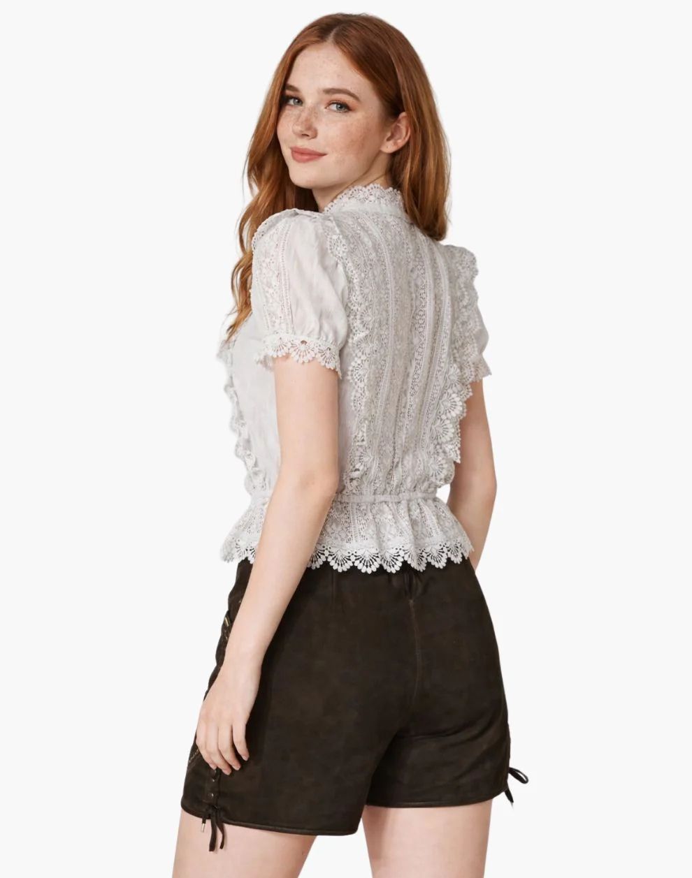 Woman wearing a white lace top and brown shorts on a white background