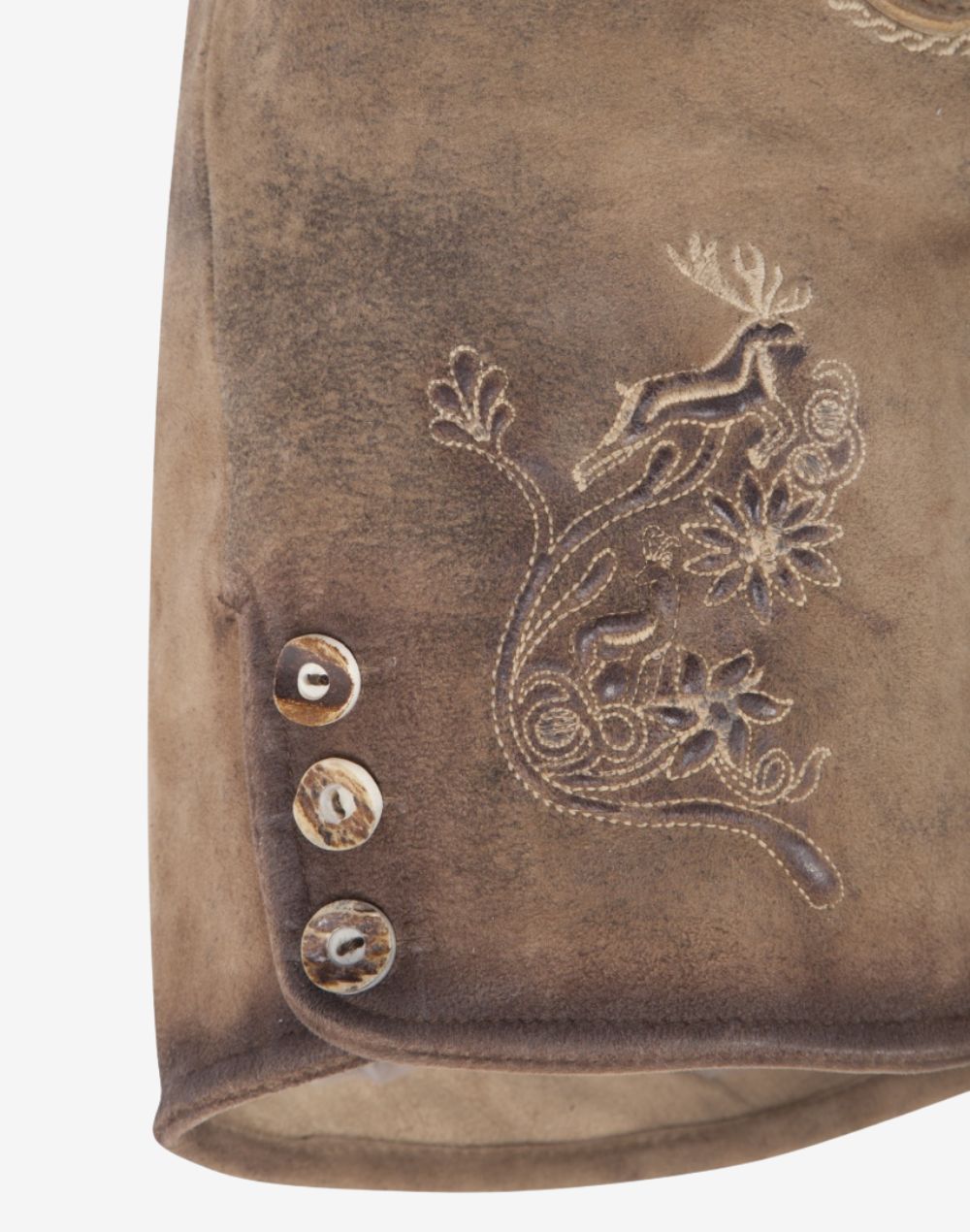 Close-up of brown suede women’s lederhosen showing traditional alpine embroidery with deer motif and decorative side buttons on a vintage distressed leather finish.