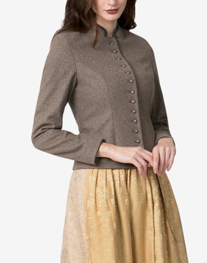 Women’s traditional Bavarian-style trachten jacket in taupe wool with a stand collar and decorative metal button front, paired with a gold patterned dirndl skirt for a classic alpine look.