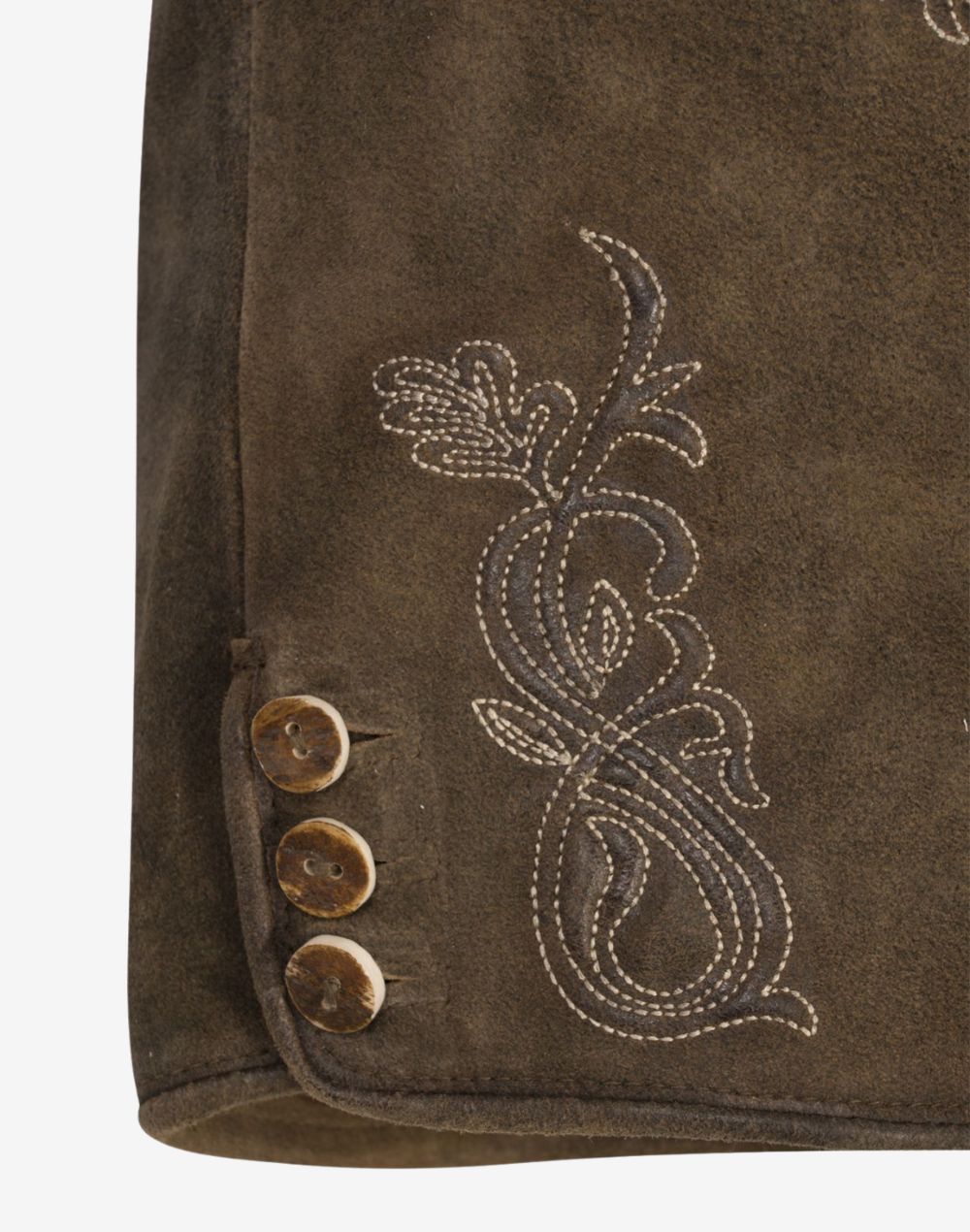 Close-up of brown leather women’s lederhosen showing traditional Bavarian floral embroidery and decorative side buttons on a vintage-style suede finish.