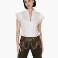 Woman wearing a white blouse and brown traditional shorts on a white background