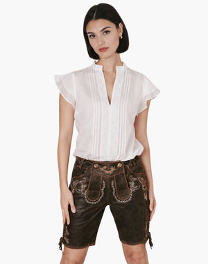 Woman wearing a white blouse and brown traditional shorts on a white background