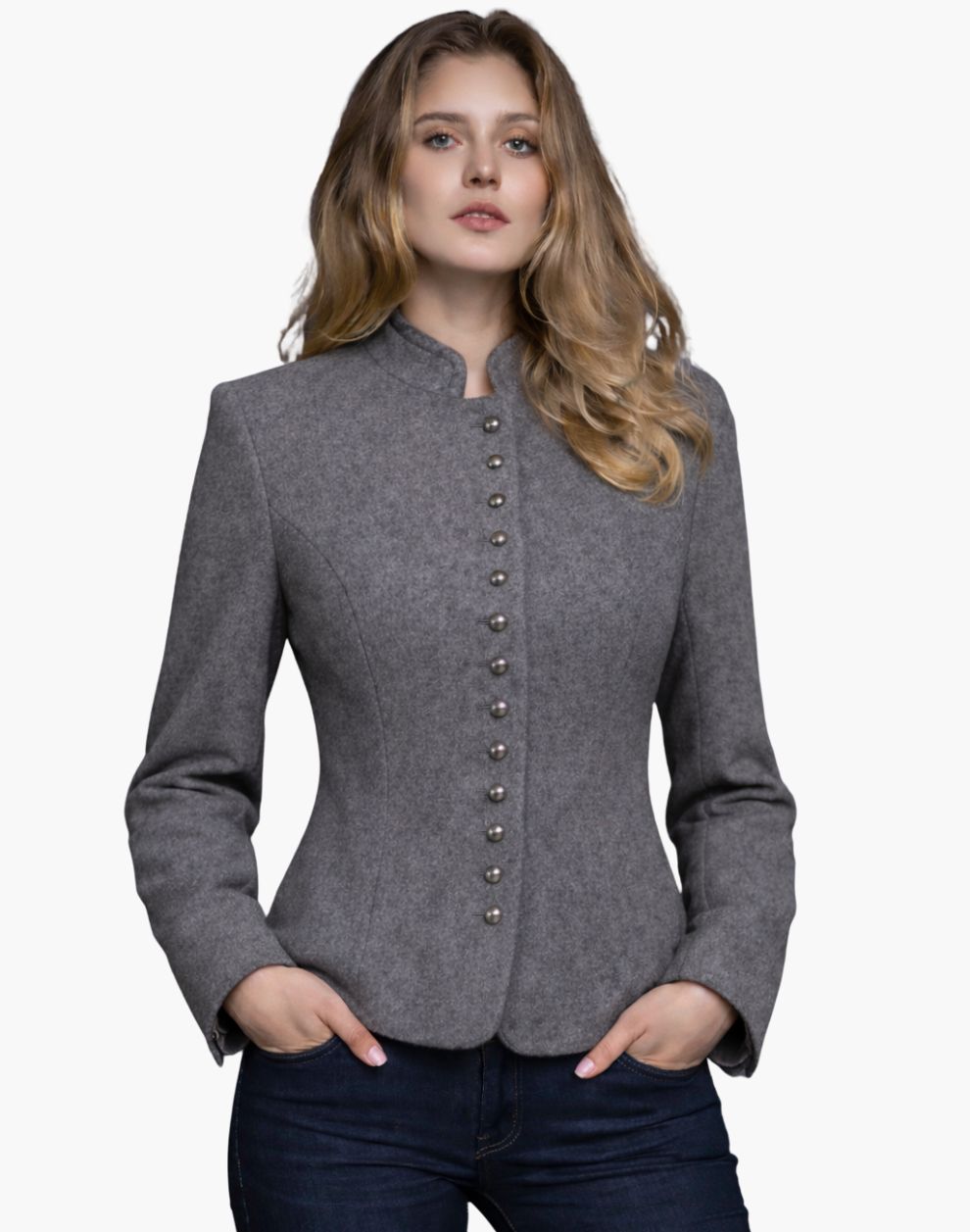Woman wearing a light grey Trachten-style jacket with decorative buttons, high collar, and a fitted tailored design, paired with dark jeans, against a white background.
